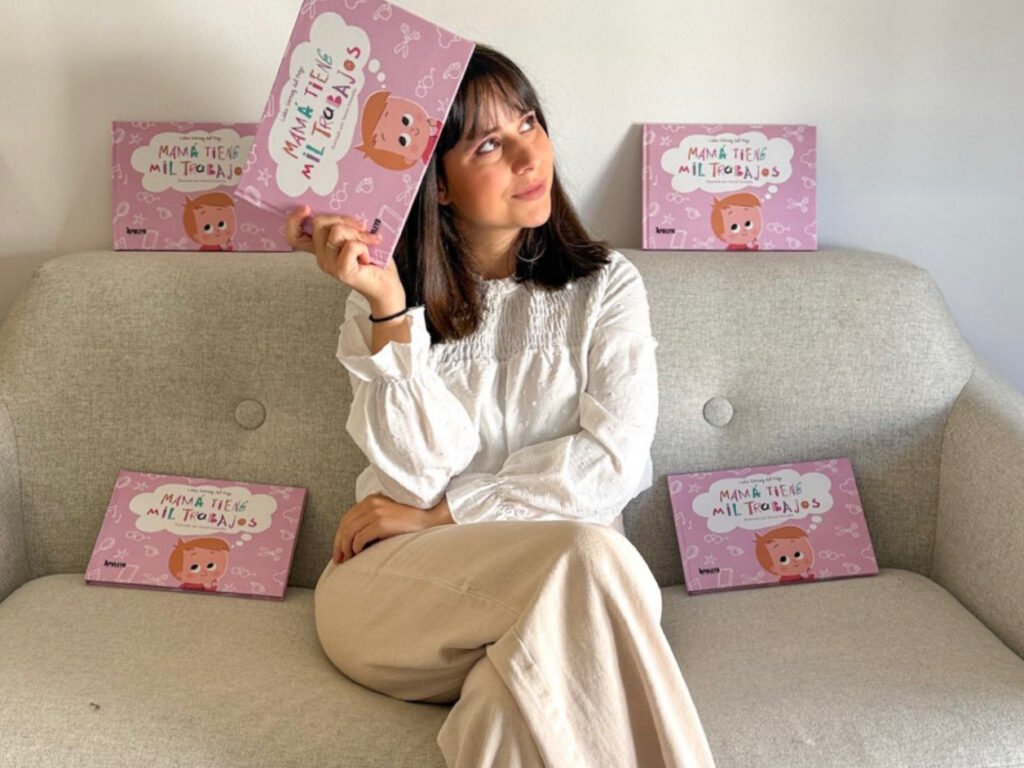 Lidia sosteniendo uno de sus libros "Mamá tiene mil trabajos"